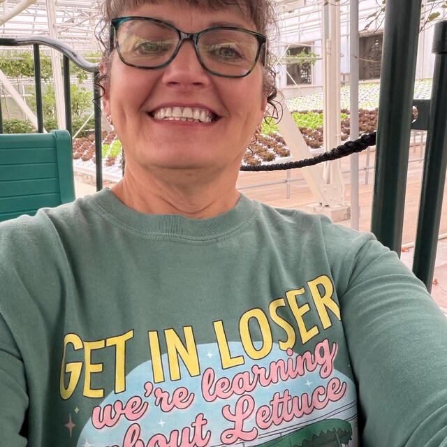 Ever After Society customer smiling in a green graphic tee during a park day
