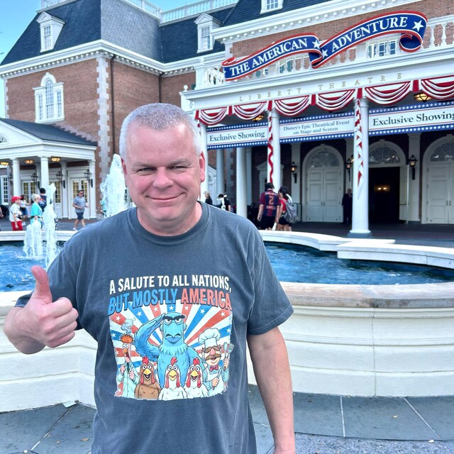 Ever After Society customer wearing a charcoal patriotic graphic tee at a theme park